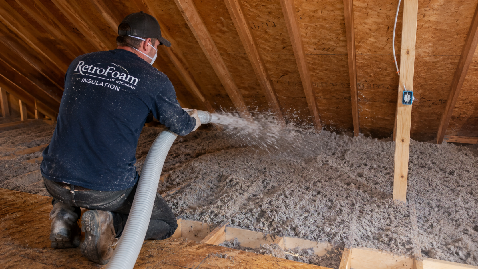 Insulation crew installing dense-packed cellulose into the exterior walls of a New England home