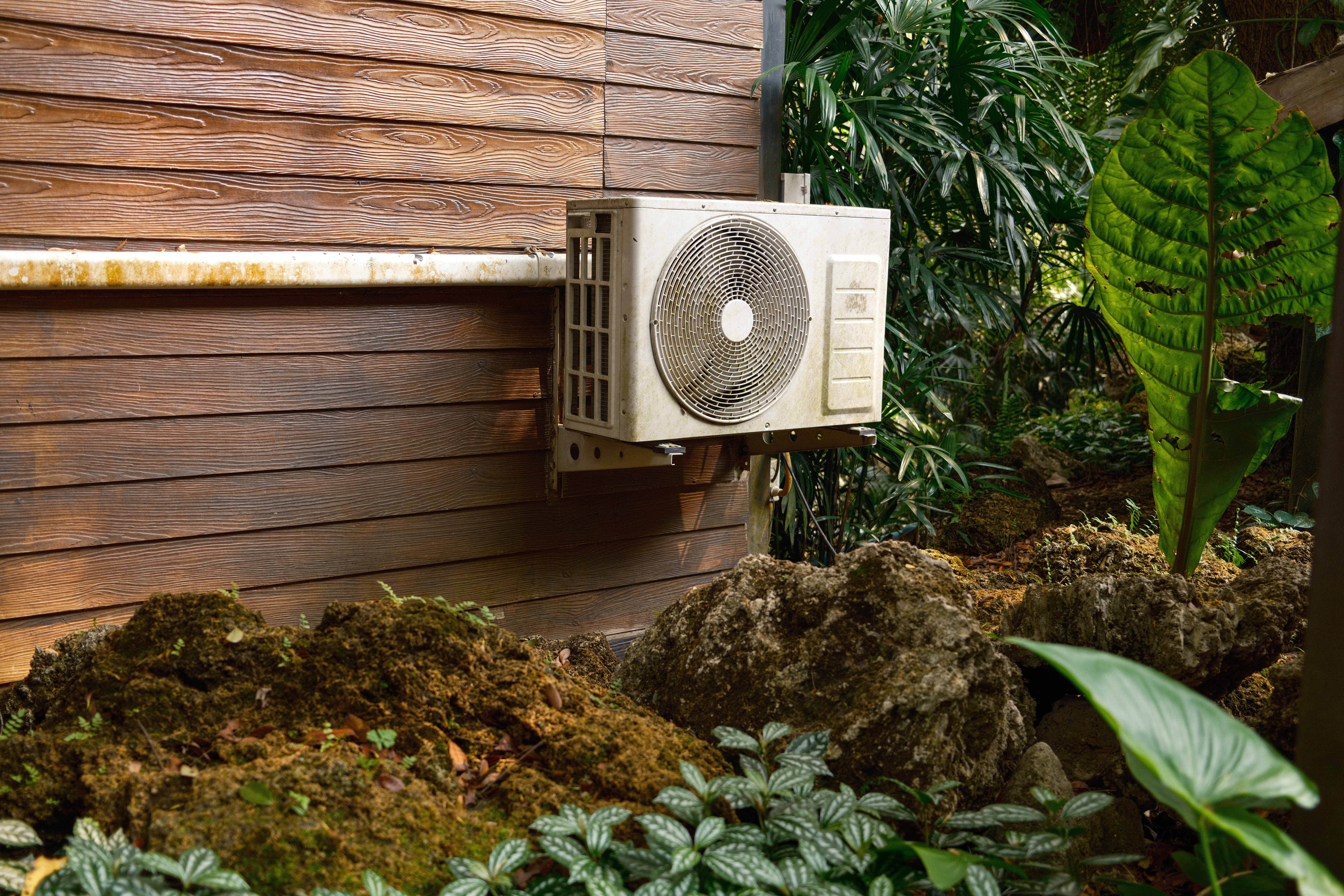 An old, weather-worn outdoor AC condenser unit reaching the end of its life